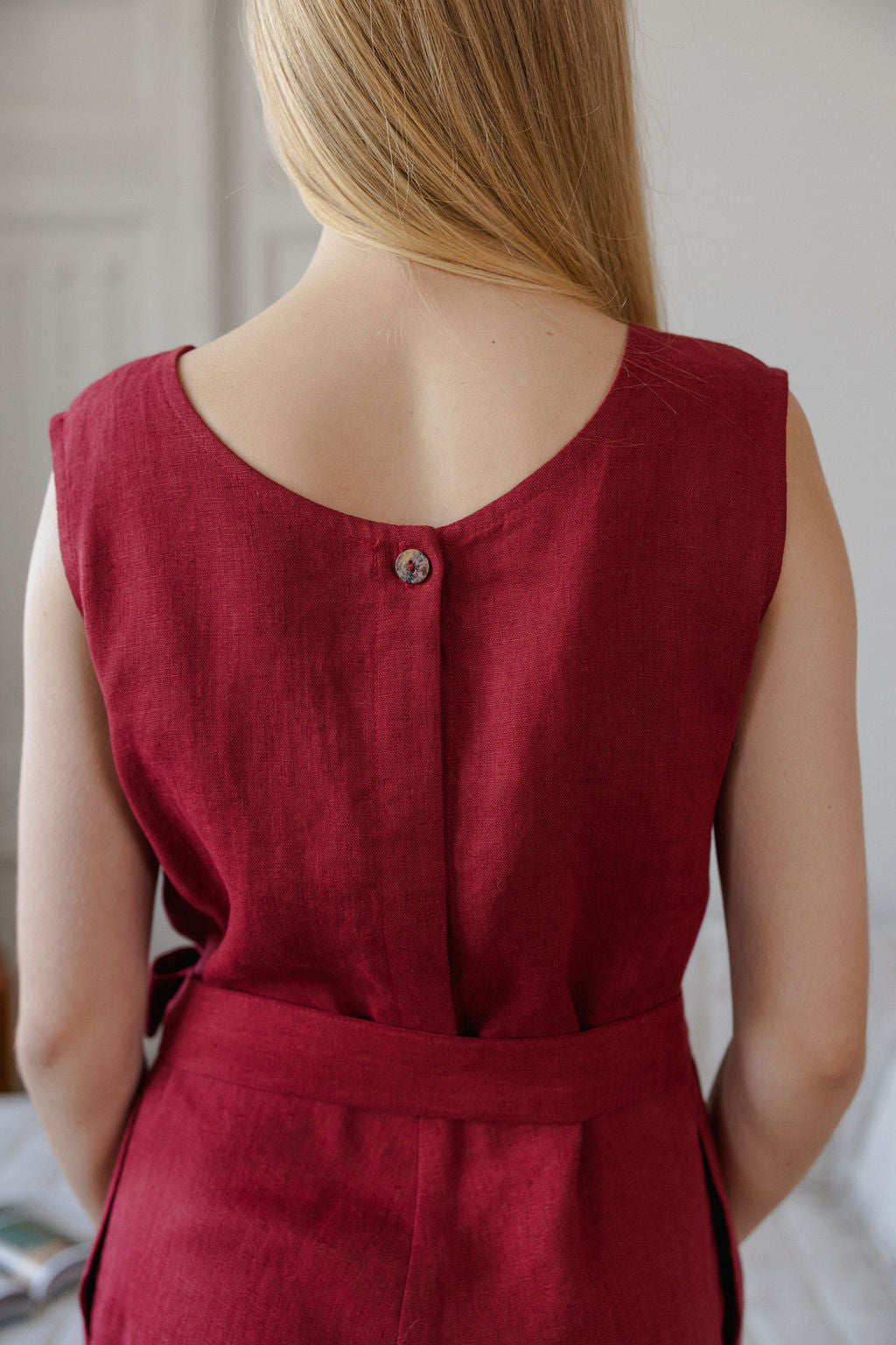 Red sleeveless dress worn by a person with a neutral background