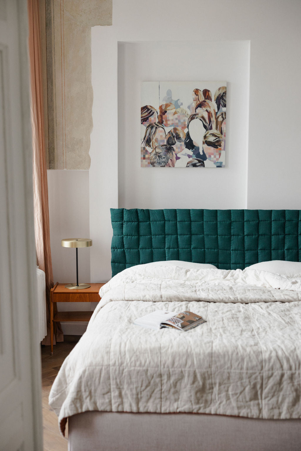 Bedroom with teal headboard and abstract painting on wall